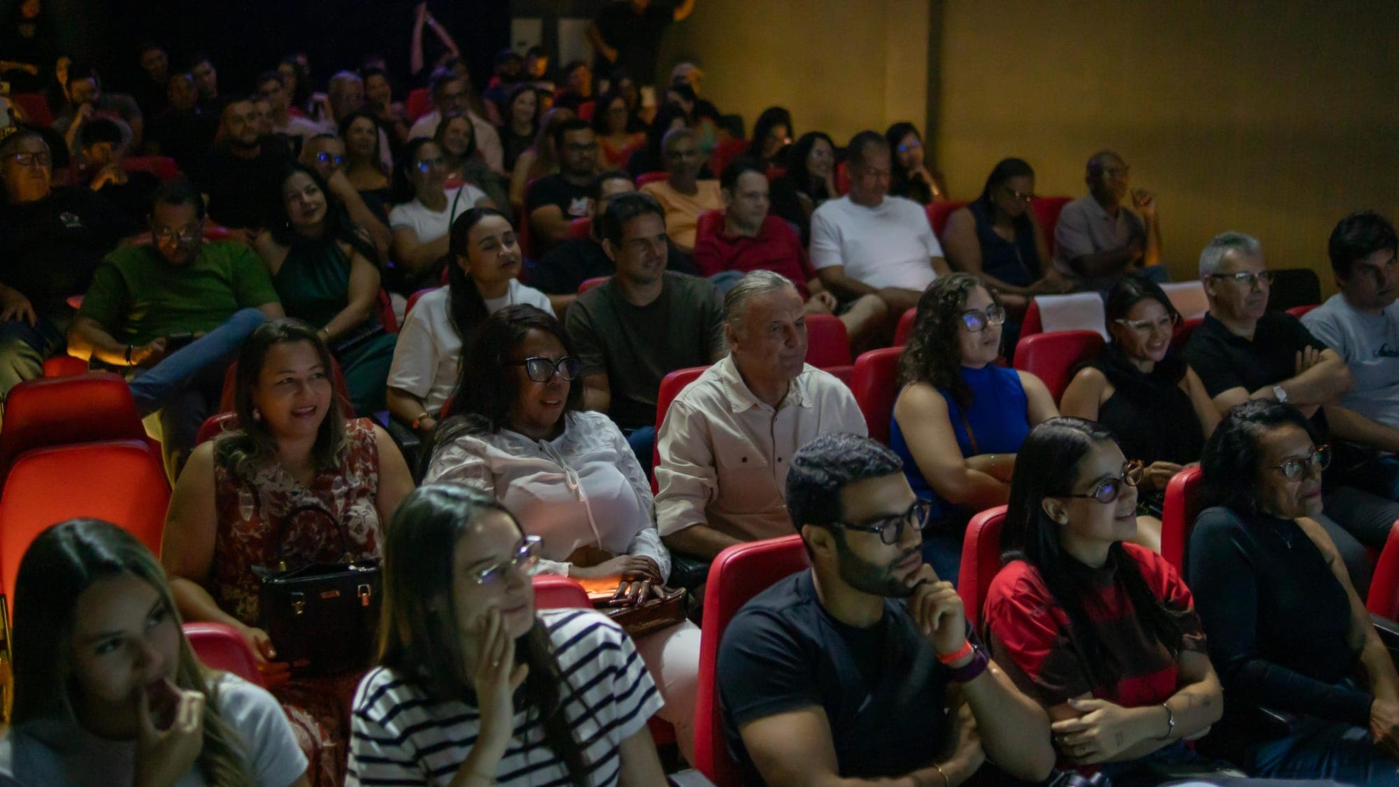 Plateia lotada do teatro acompanhando a apresentação